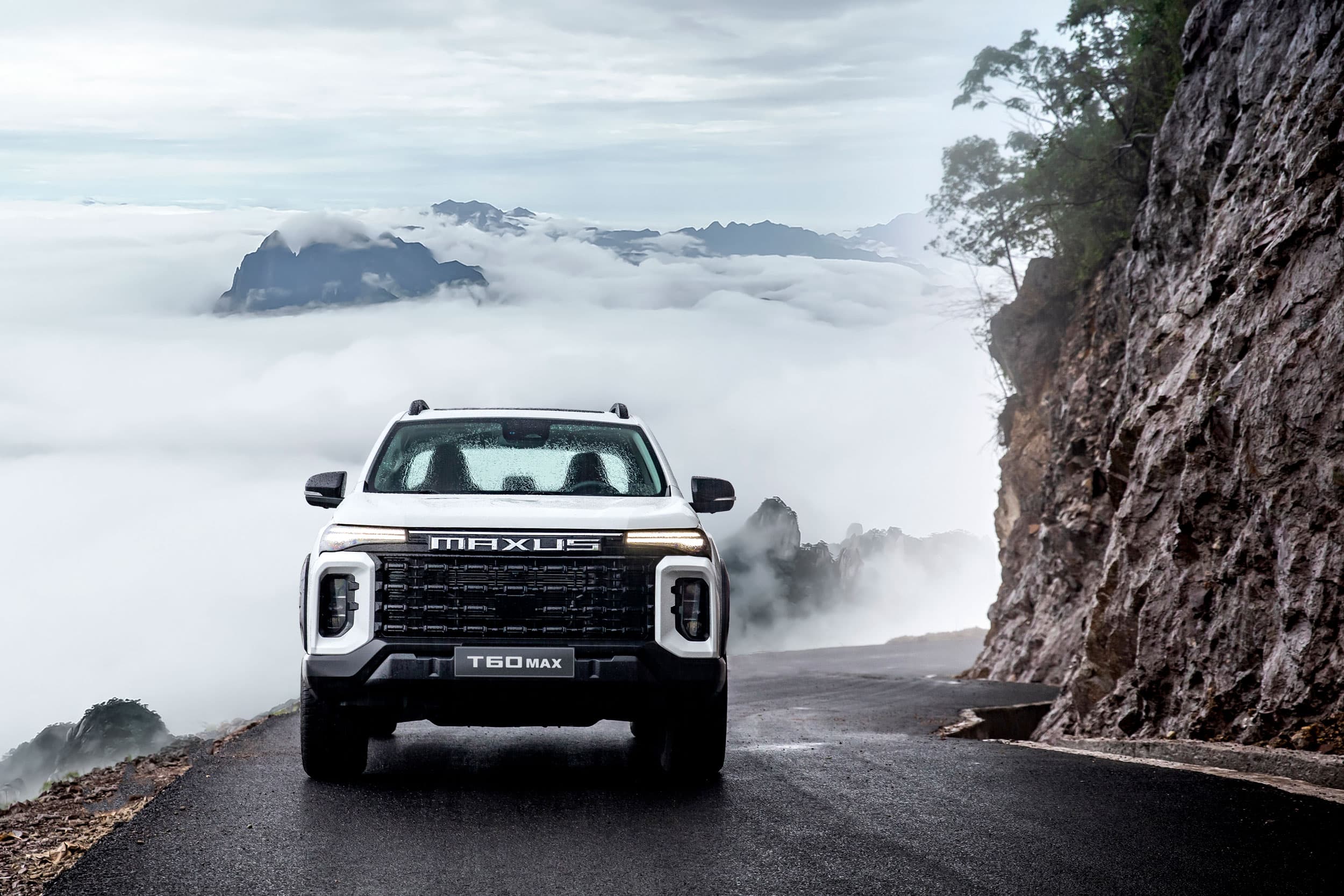 Maxus T60 Max driving on a road in the clouds (warm white)